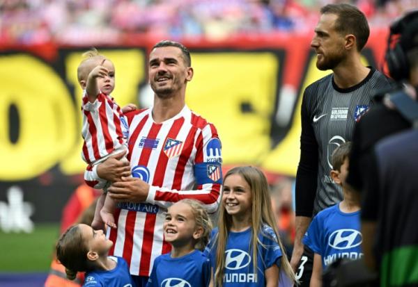 L'attaquant français de l'Atlético Madrid Antoine Griezmann porte sa fille Shai avant le début du match de Liga contre Gérone, le 17 mai 2026 au Metroplitano