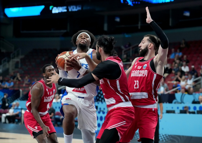 Le capitaine des Bleus Guerschon Yabusele pris en étau dans la défense géorgienne, lors des 8e de finale de l'Euro de basket, le 7 septembre 2025 à Riga