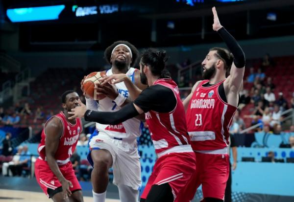 Le capitaine des Bleus Guerschon Yabusele pris en étau dans la défense géorgienne, lors des 8e de finale de l'Euro de basket, le 7 septembre 2025 à Riga