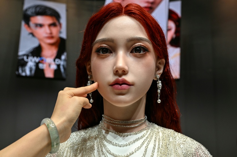 Une femme touche la peau d'un robot androïde U1 présenté à Shenzen, le 30 juin 2026 dans la province chinoise du Guangdong