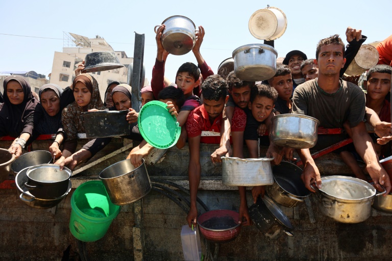 Des Palestiniens affamés attendent de recevoir une ration de soupe de lentilles lors d'une distribution alimentaire à Gaza, le 2 août 2025