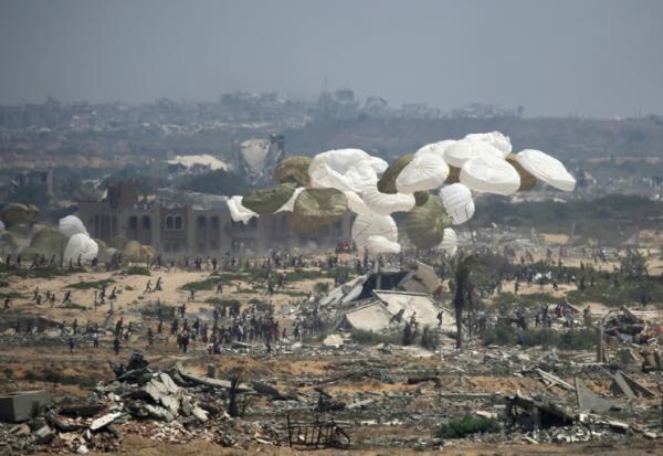 Des palettes d'aide humanitaire sont larguées par un avion militaire au-dessus de Nousseirat, dans le centre de la bande de Gaza, le 18 août 2025