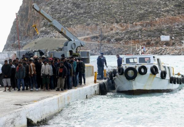 Des migrants débarquent d'un bateau au port de Kali Limenes, à Héraklion, dans le sud de la Crète, le 21 février 2026
