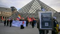 Des membres du syndicat CGT manifestent devant l'entrée du Louvre, à Paris, le 15 décembre 2025
