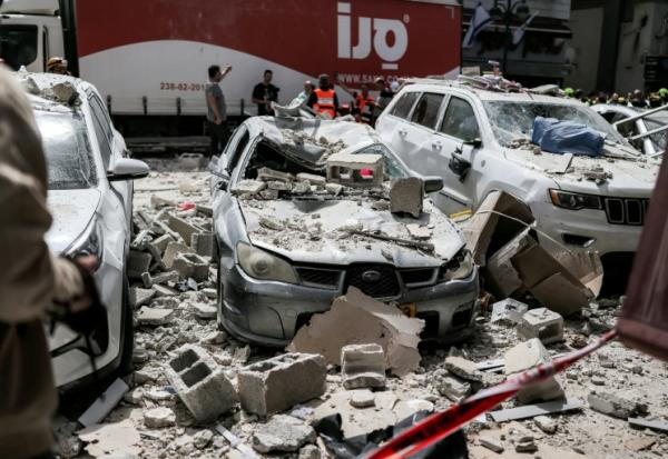 Des véhicules endommagés devant un bâtiment touché par une attaque iranienne à Ramat Gan, dans le centre d'Israël, le 6 avril 2026