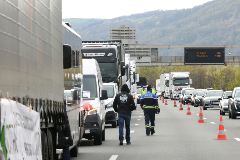 Un policier sur le site d'une manifestation de chauffeurs routiers bloquant l'autoroute A7, au sud de Lyon, pour protester contre la hausse des prix du carburant, à Chasse-sur-Rhône, le 28 mars 2026 en Isère