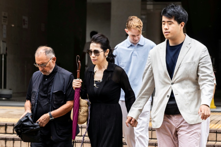 Teresa Lai, l'épouse de Jimmy Lai, et leur fils  Lai Shun Yan (à droite) quittent le tribunal de Hong Kong où le magnat des médias est jugé, le 15 août 2025
