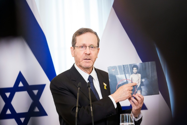 Le président israélien Isaac Herzog, en visite à Riga le 5 août 2025, montre une photo tirée d'une vidéo publiée par le Hamas, montrant l'otage Evyatar David, retenu dans la bande de Gaza