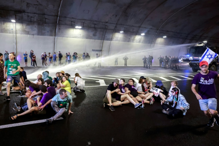 La police israélienne utilise un canon à eau pour disperser des manifestants bloquant la circulation dans un tunnel à Jérusalem, le 17 août 2025