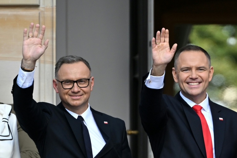 Le nouveau président polonais Karol Nawrocki (d) et son prédécesseur Andrzej Duda lors d'une cérémonie d'investiture officielle au palais présidentiel le 6 août 2025 à Varsovie