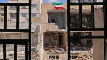 Un drapeau iranien sur le pan de mur d'un immeuble résidentiel endommagé par de récentes frappes à Karaj, au sud-ouest de Téhéran, le 3 avril 2026 