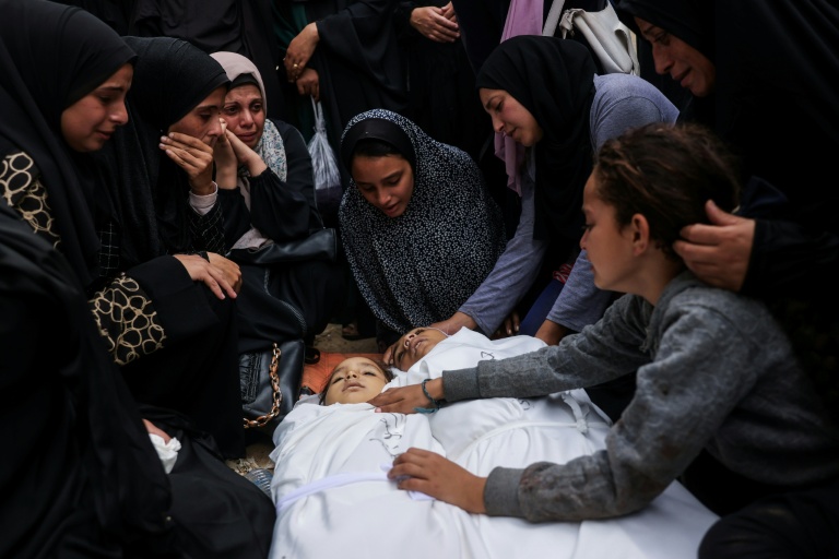 Des proches veillent les corps de deux enfants tués dans une frappe israélienne, le 29 octobre 2025 à Nousseirat, dans le centre de la bande de Gaza
