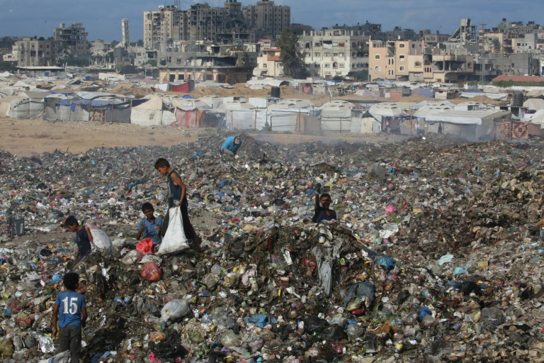 Des enfants palestiniens cherchent des objets à récupérer parmi des ordures près du camp de réfugiés de Bureij, dans le centre de la bande de Gaza, le 6 octobre 2025