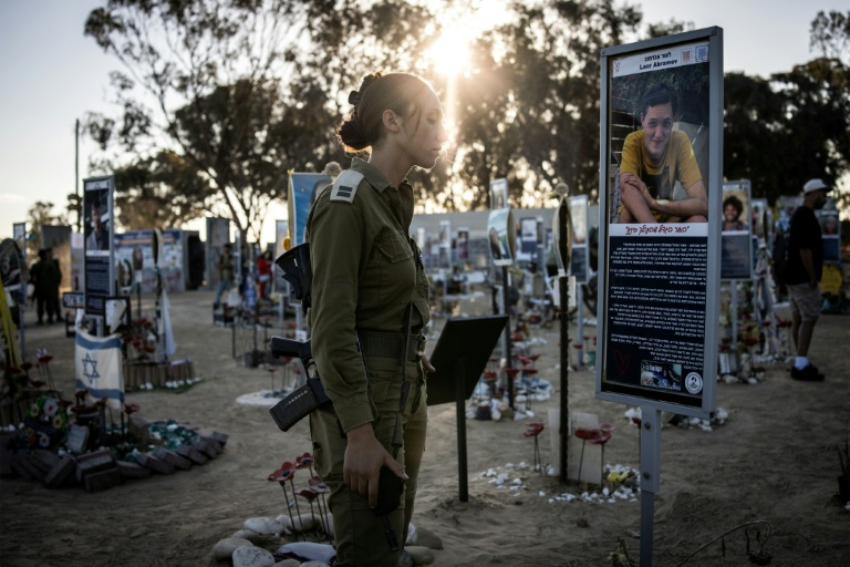 Une soldate israélienne se recueille au mémorial des victimes de l'attaque du Hamas à Réïm, dans le sud d'Israël, le 7 octobre 2025, jour du deuxième anniversaire de l'attaque