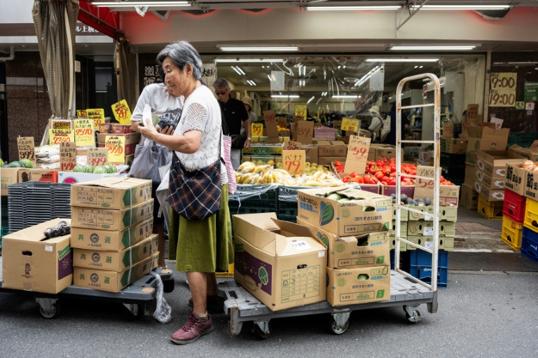 Une cliente achète des légumes sur un marché de Tokyo, le 17 août 2026