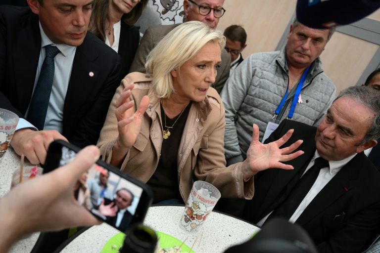 La présidente du groupe parlementaire du Rassemblement national (RN), Marine Le Pen (c), s'adresse aux médias en marge d'une visite au sommet de l'élevage à Cournon-d'Auvergne, près de Clermont-Ferrand, le 8 octobre 2025 dans le Puy-de-Dôme