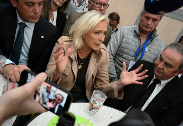 La présidente du groupe parlementaire du Rassemblement national (RN), Marine Le Pen (c), s'adresse aux médias en marge d'une visite au sommet de l'élevage à Cournon-d'Auvergne, près de Clermont-Ferrand, le 8 octobre 2025 dans le Puy-de-Dôme