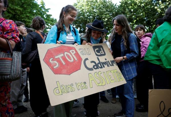 Des manifestants brandissent une pancarte sur laquelle on peut lire "Stop au cadmium dans nos assiettes" lors d'une manifestation aux côtés de députés, sur l'esplanade des Invalides à Paris, le 2 juin 2026