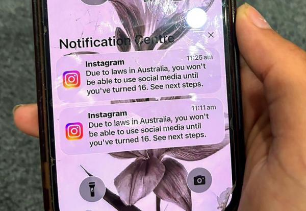 Un adolescent tient un téléphone portable affichant un message du réseau social Instagram après que son compte a été verrouillé en raison de son âge, à Sydney, le 9 décembre 2025