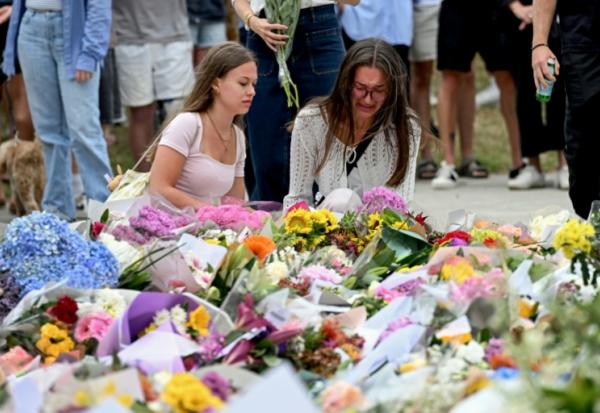 Des personnes se se recueillent devant le Bondi Pavillion, en mémoire des victimes de la fusillade de la plage de Bondi, à Sydney, le 15 décembre 2025 en Australie
