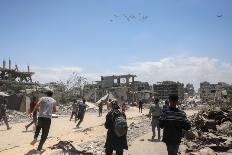 Des Palestiniens se précipitent pour recueillir de l'aide humanitaire qu'un avion vient de larguer à Jabalia, dans le nord de la bande de Gaza, le 1er août 2025
