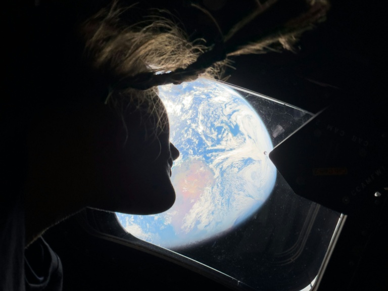 Photo prise par un membre de l'équipage d'Artemis II et diffusée par la Nasa, montrant Christina Koch  regardant la Terre par le hublot du vaisseau spatial Orion, le 2 avril 2026