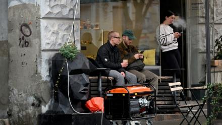 Un générateur en marche devant un café à Kiev durant une coupure de courant causée par des frappes russes sur des installations électriques, le 18 octobre 2026