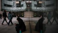 Des passants marchent devant l'entrée des bureaux de la BBC à Londres le 11 novembre 2025
