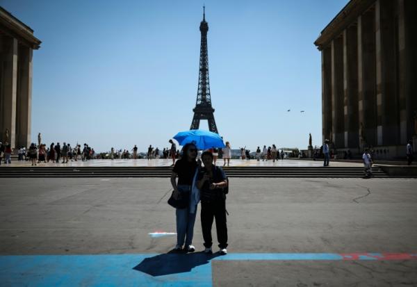 Des touristes se protègent du soleil au Trocadéro à Paris, le 18 juin 2026