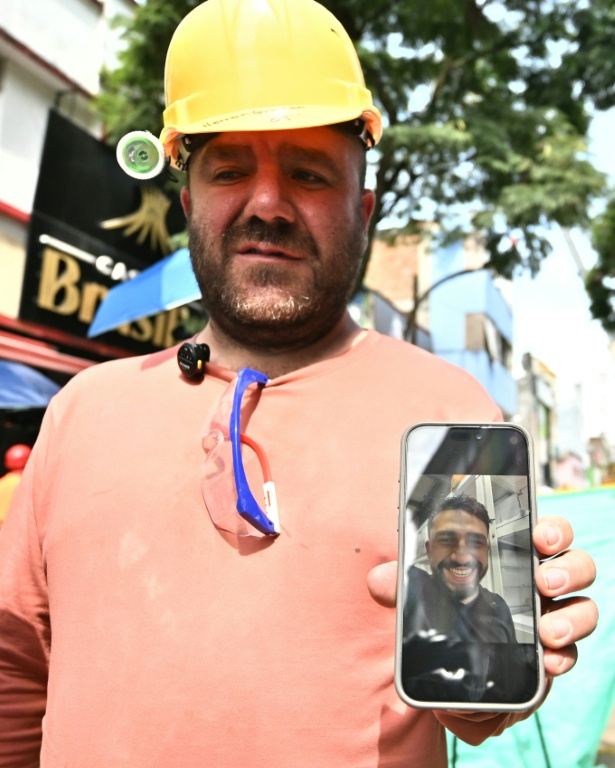 Hernan Giraldo montre une photo de son fils Juan Felipe Giraldo, qu'il recherche toujours à Pereira, en Colombie, le 14 août 2026