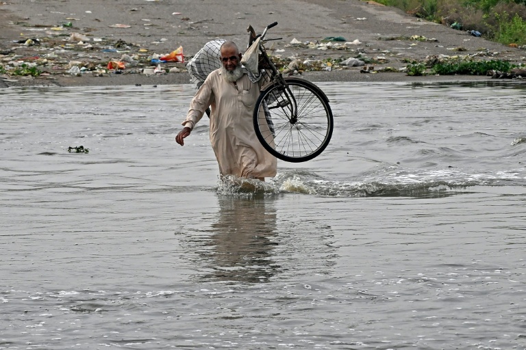 Un homme traverse une rue inondée de Karachi, mégapole du Pakistan où les pluies de mousson ont fait plus de 400 morts en une semaine, le 20 août 2025
