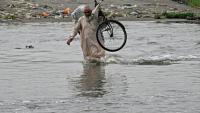Un homme traverse une rue inondée de Karachi, mégapole du Pakistan où les pluies de mousson ont fait plus de 400 morts en une semaine, le 20 août 2025
