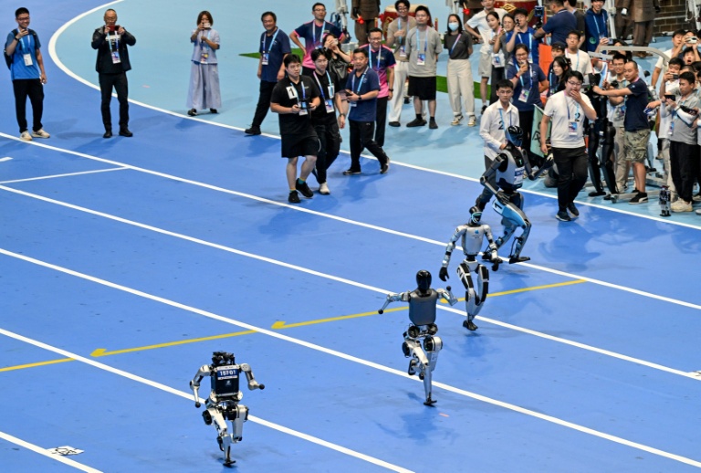 Des robots s'affrontent sur un 100 mètres durant la cérémonie d'ouverture de la première compétition mondiale de robots humanoïdes à Pékin, le 14 août 2025