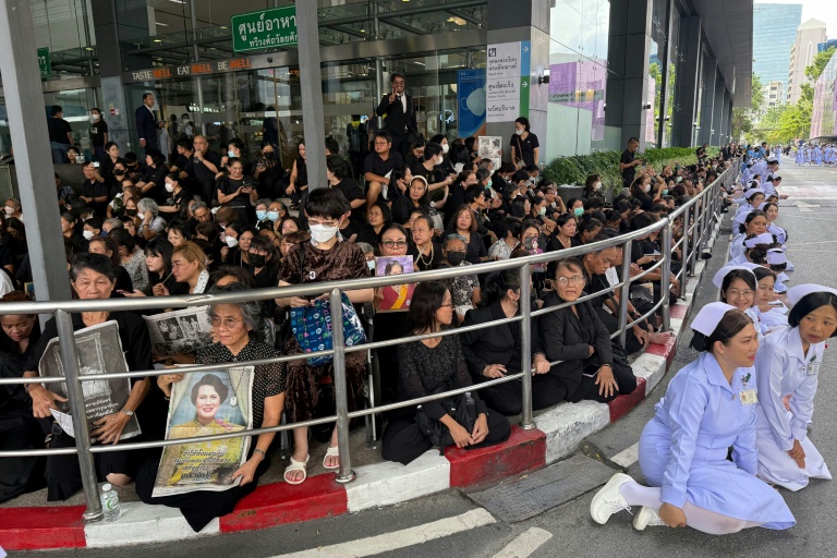 Des habitants et des infirmières rendent hommage à la dépouille de la reine mère Sirikit, à son départ de l'hôpital Chulalongkorn jusqu'au palais royal de Bangkok, le 26 octobre 2025