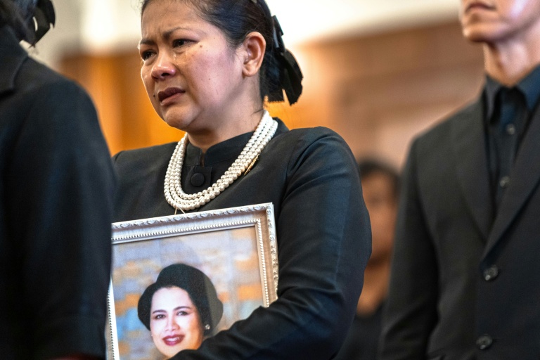 Une femme endeuillée pleure dans la file d'attente pour rendre hommage à la reine mère Sirikit de Thaïlande au Grand Palais de Bangkok, le 26 octobre 2025