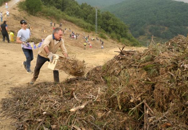 Des habitants réalisent des travaux de déboisement en prévision d'un possible arrivée du feu provenant de l'incendie du parc national des Picos de Europa, dans la ville de Riano, en Castille-et-León, en Espagne, le 18 août 2025