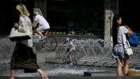 Un enfant se rafraîchit dans une fontaine à Belgrade, le 26 juin 2026 en Serbie, lors d'un épisode de canicule en Europe