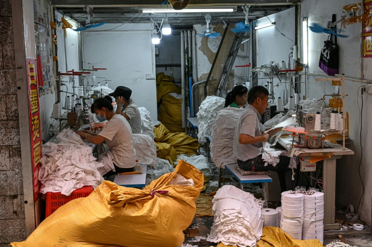 Des ouvriers confectionnant des vêtements dans un petit atelier de Canton, dans le sud de la Chine, le 16 avril 2026