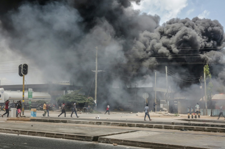 Des manifestants près de bâtiments en flammes et de barricades pendant des affrontements à Dar es Salaam ,le 29 octobre 2025, pendant les élections présidentielles en Tanzanie