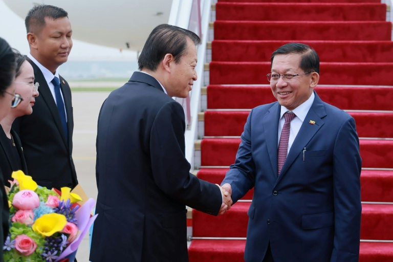 Photo diffusée le 15 juin 2026 par le Bureau de presse et d'information de la présidence birmane, montrant le président birman Min Aung Hlaing (d) accueilli par un responsable chinois à son arrivée à Pékin