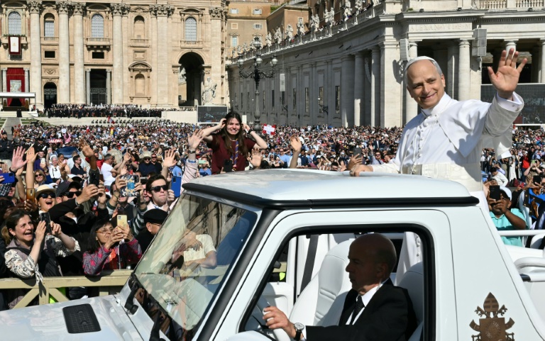 Le pape Léon XIV salue la foule depuis la papamobile avant une messe pour le début de son pontificat, sur la place Saint-Pierre au Vatican le 18 mai 2025.