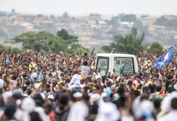 Le pape Léon XIV (C) salue la foule depuis la papamobile à son arrivée à l'aéroport de Yaoundé Ville, au sixième jour d'un voyage apostolique de 11 jours en Afrique, le 18 avril 2026.