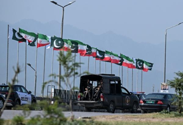 Des drapeaux iraniens et pakistanais le long de la route empruntée par le cortège du président iranien Massoud Pezeshkian à son arrivée à Islamabad, le 23 juin 2026 au Pakistan