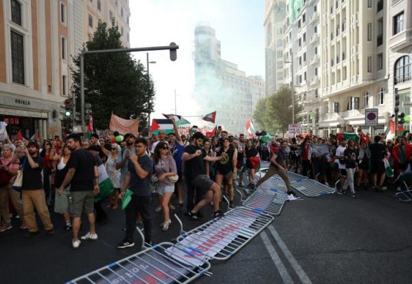 Des manifestants propalestiniens envahissent la rue pendant la 21e et dernière étape du Tour d'Espagne cycliste, le 14 décembre 2025 à Madrid