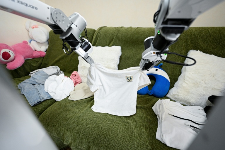 Un robot de ménage X Square plie des vêtements au domicile d'une cliente, le 21 mai 2026 à Pékin, en Chine