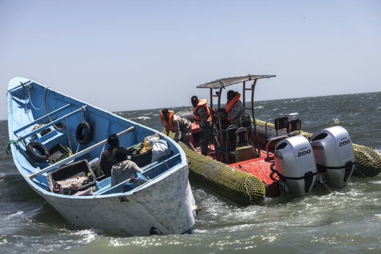 Des garde-côtes mauritaniens montent à bord d'une pirogue de pêche pour vérifier les documents et les permis de pêche lors d'une patrouille au large de Nouadhibou (Mauritanie), le 23 avril 2026