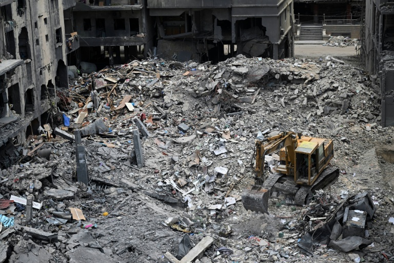 Des ouvriers déblaient avec une pelleteuse les décombres d'un bâtiment par une précédente frappe militaire israélienne sur un quartier de Tyr, dans le sud du Liban, le 23 juin 2026