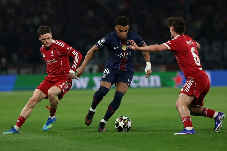 Florian Wirtz (G) de Liverpool voit filer Désiré Doué (C) du Paris SG lors de la victoire 2 à 0 des Parisiens, en quart de finale aller de Ligue des champions, le 8 avril 2026 au Parc des Princes