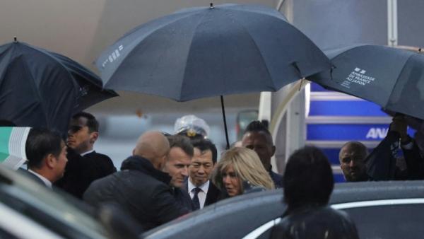 Le président français Emmanuel Macron (c,g) et son épouse Brigitte Macron à leur arrivée à l'aéroport de Tokyo, le 31 mars 2026