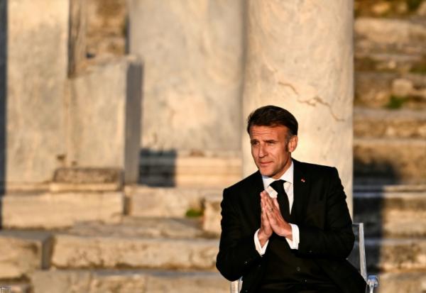 Le président français Emmanuel Macron salue le public à son arrivée sur scène lors d'un événement à l'Agora romaine d'Athènes, le 24 avril 2026 en Grèce